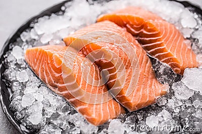 Portioned raw salmon fillets in ice on plate - Close-up Stock Photo