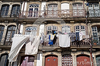 Porto, Portugal - January 20, 2020: Typical scene in urban Porto, with laundry hanging out to dry on the balcony in downtown area Editorial Stock Photo