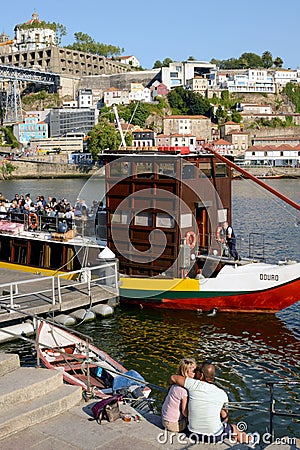 Embankment of the Douro River, resting tourists. A pair of lovers kiss on the river bank. Romantic journey Editorial Stock Photo