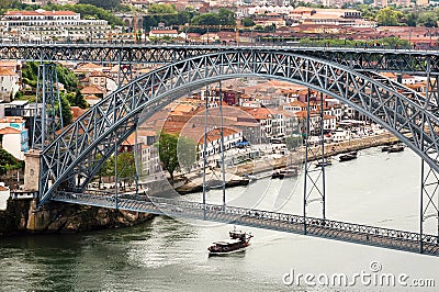 Riverboat sailing on the river Douro, with double-deck metal arch bridge Editorial Stock Photo