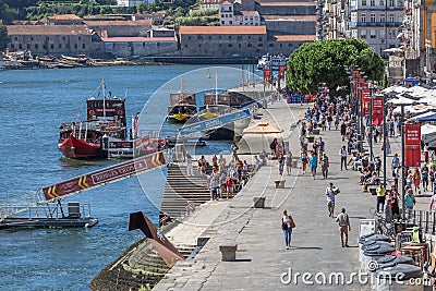 View of Ribeira docks on Porto downtown, with tourist people, recreational boats, Douro river and buildings Editorial Stock Photo