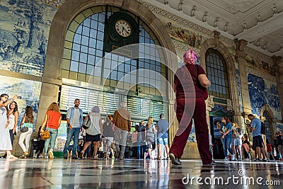 Porto, Portugal - 08/28/2019: Woman with pink hair walking. SÃ£o Bento train station. Crowd of people walking Editorial Stock Photo