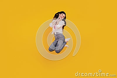 Portrait of adorable positive girl jump posing on yellow background Stock Photo