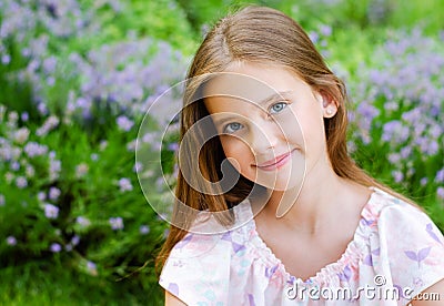 Portrait of adorable smiling little girl child in summer day. Happy preteen in the park Stock Photo