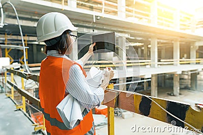Portrait of adult female builder, engineer, architect, inspector, manager at construction site. Woman makes photo of building Stock Photo