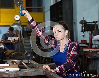 Portrait of adult female working with lift hook Stock Photo