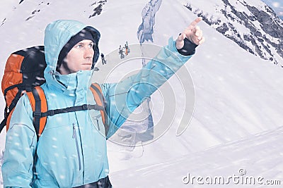 Portrait of adventurous young man on winter mountainside view pointing out. Snowboarders walking uphill for freeride Stock Photo