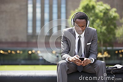 Portrait of African American Businessman listening to music with headphones outdoors Stock Photo