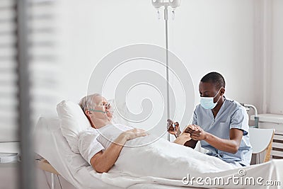 Male Nurse Setting Up IV Drip Stock Photo