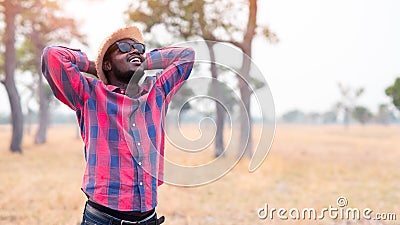 Portrait of african traveler smiling and enjoying his recreation time in nature.Concept of tourism day Stock Photo