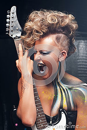Portrait of aggressive screaming punk with guitar Stock Photo