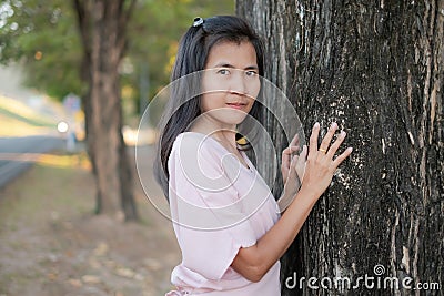 Portrait alone woman standing with big tree nature in park. Stock Photo