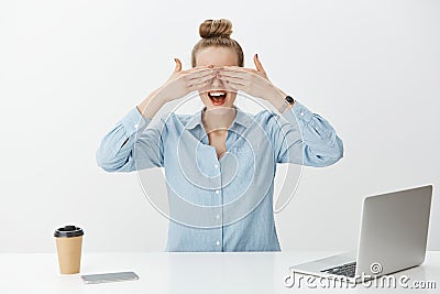 Portrait of amazed good-looking female entrepreneur in office, covering eyes with palms and waiting impatiently for Stock Photo