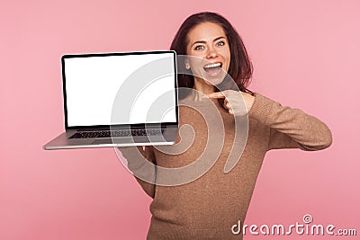 Portrait of amazed woman pointing at laptop with white screen copy space, mock up display for internet advertising Stock Photo