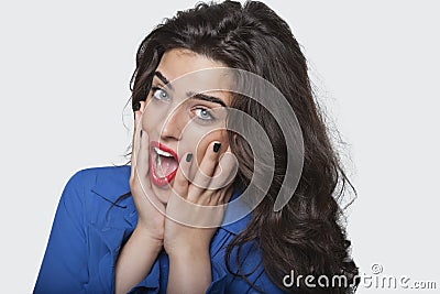 Portrait of an amazed young woman over gray background Stock Photo