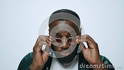 Portrait of ambitions african man putting sunglasses in grey background. Stock Photo