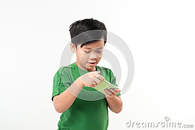 Portrait of an amused cute little kid playing games on smartphone isolated over white background Stock Photo
