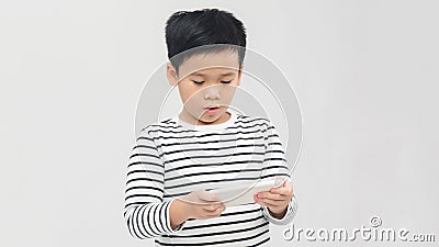 Portrait of an amused cute little kid playing games on smartphone isolated over white background Stock Photo