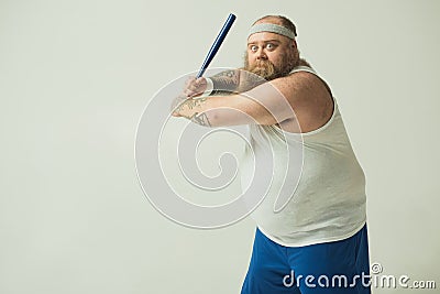 Irritated thick guy attacking with a club Stock Photo