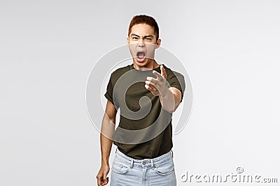 Portrait of angry heartbroken asian boyfriend being cheated on, accuse person for betraying him, pointing fingers and Stock Photo