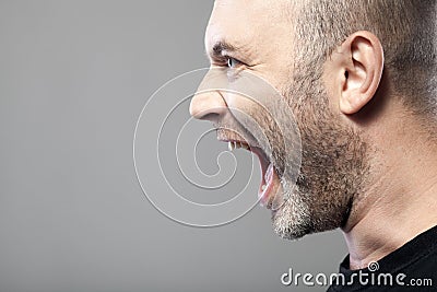 Portrait of angry man sreaming isolated on gray background Stock Photo