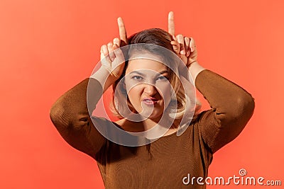 Angry girl showing bull horns on head Stock Photo