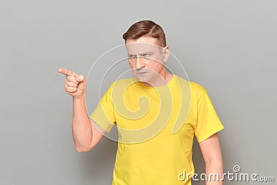 Portrait of angry strict man looking and pointing with finger aside Stock Photo