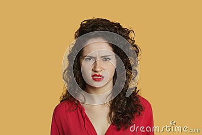 Portrait of angry young woman frowning over colored background Stock Photo