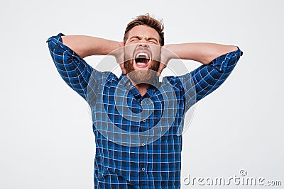 Portrait of an annoyed bearded man covers his ears Stock Photo