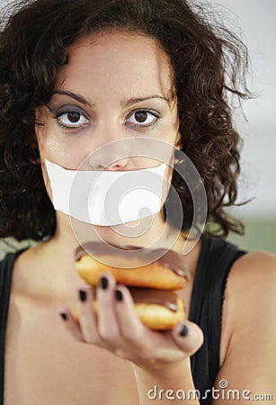 Portrait, anorexia and woman with donut and tape over mouth to stop eating, unhappy and delusional. Face, covering and Stock Photo