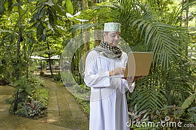 Portrait of Arab muslim business man dress in white thobe with p Stock Photo