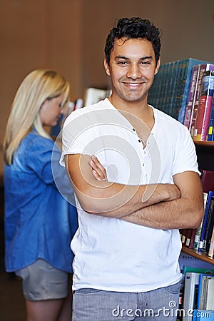 Portrait, arms crossed or happy man in a library for knowledge or development for future growth. Scholarship, education Stock Photo