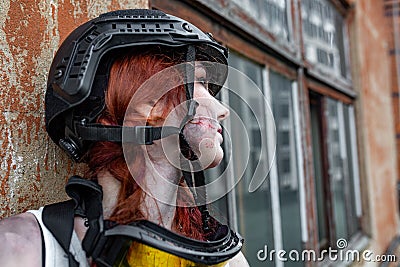 Portrait of army girl with rifle in camouflage clothes in urban scene, in hiding Stock Photo