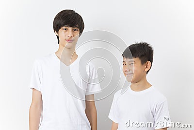 Portrait of Asian boy and caucasian teen on white background. Stock Photo