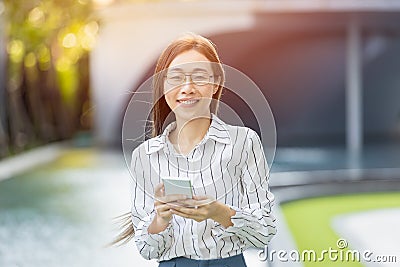 Portrait Asian business women adult smart woman standing looking camera with smartphone Stock Photo