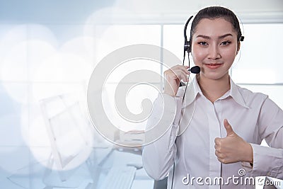 Portrait Asian callcenter operator thumbs up. Helpdesk support phone call customer care female staff smiling with headset good Stock Photo