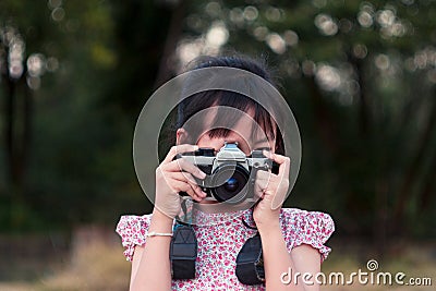 Portrait of asian cheerful little girl taking photo with film camera Stock Photo