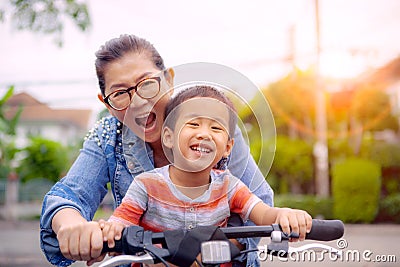 Portrait of asian children riding bicycle with mother smiling face happiness emotion Stock Photo