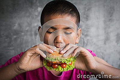 Portrait Asian fat boy enjoy eating with hamburger Stock Photo