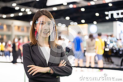 Portrait of Asian female car seller wearing face shield selling car Stock Photo