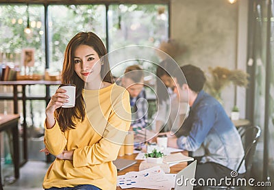 Portrait of asian female creativity working team coworking office ,Smiling of happy beautiful woman Hand Holding Coffee Cup Stock Photo