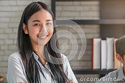 Portrait of Asian female student with bookshelf in library Stock Photo