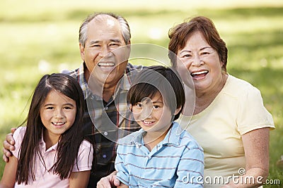 Portrait Asian grandparents and grandchildren in park Stock Photo