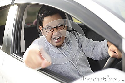 Angry Asian Male Driver, Screaming Pointing From His Car Stock Photo