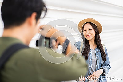 Portrait of Asian man and woman couple travelers in relationship. Boyfriend taking a photo of girlfrind in front of Stock Photo