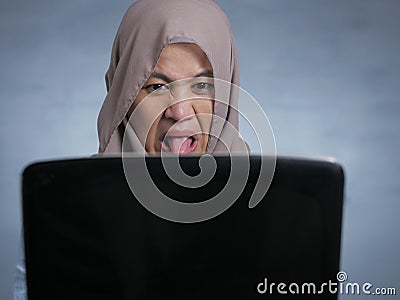 Muslim Woman Watching Disgusted Movie on Laptop Stock Photo