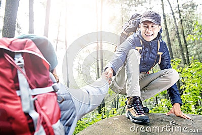 Portrait of asian traveler man helping woman climbing up Stock Photo