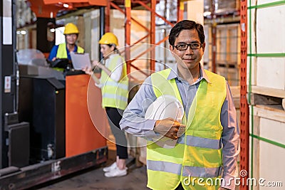 Portrait of asian warehouse manager with warehouse worker in background Stock Photo