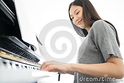 Portrait Asian woman playing playing piano. Stock Photo