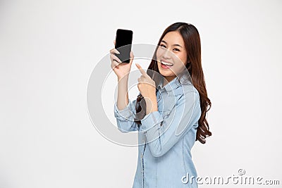 Portrait of Asian woman showing or presenting mobile phone application and pointing finger to smartphone. Stock Photo